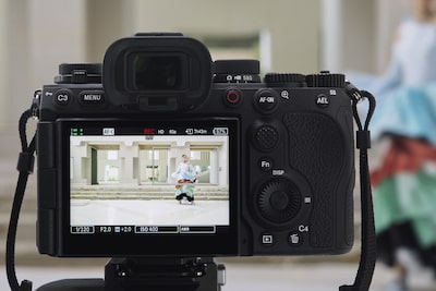 Usage image showing the camera mounted on a tripod, shooting a woman