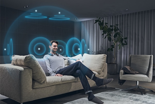 Image of man in living room watching BRAVIA TV with 360 Spatial Sound