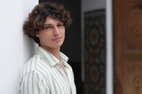 Example image of a male model smiling towards the camera with bokeh background